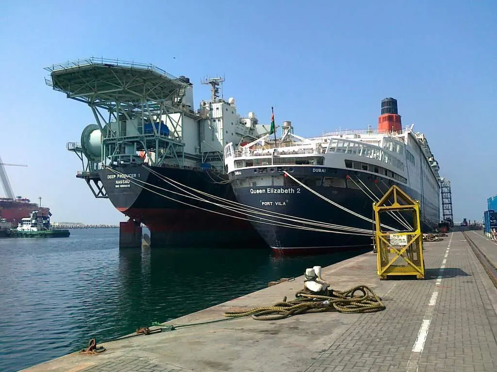 Cruise ship docked at Dubai's Port Rashid terminal with the city skyline in the distance