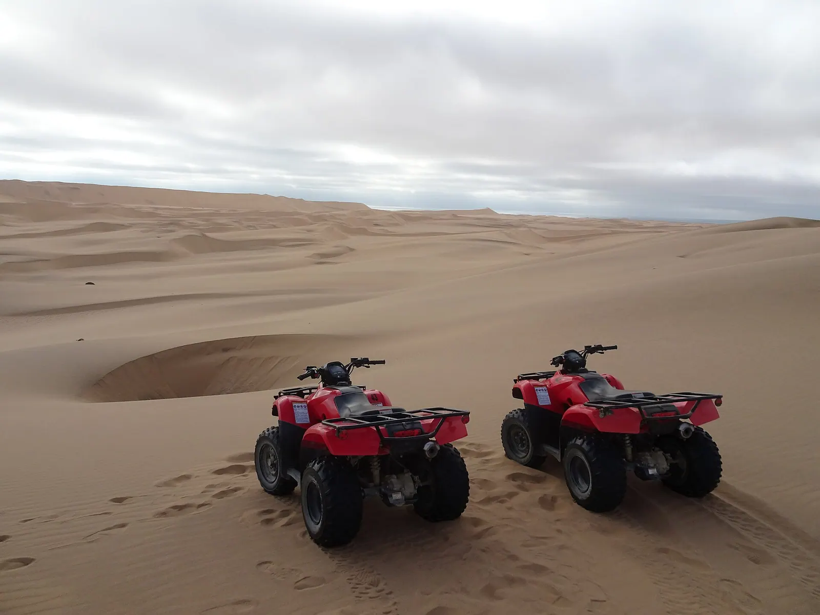 Rider navigating a powerful quad bike across desert sand dunes in Dubai